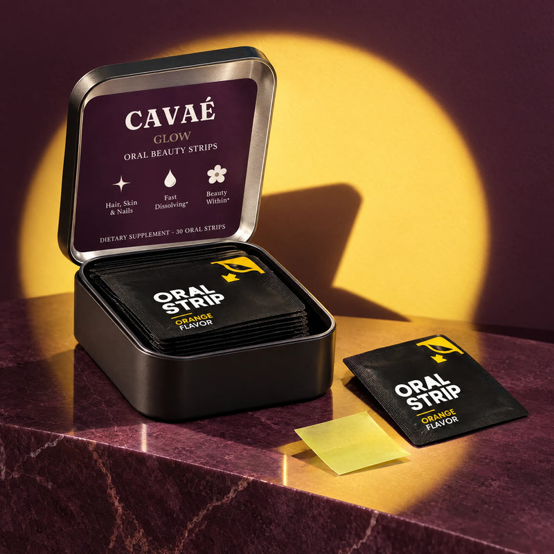 Open CAVAÉ GLOW tin with orange sachets, an oral strip and fresh orange slices.